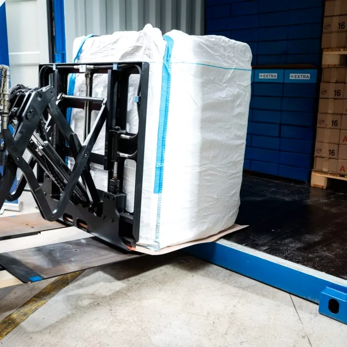 Forklift push-pull attachment loading bulk bags on a slip sheet into a container, no pallet used